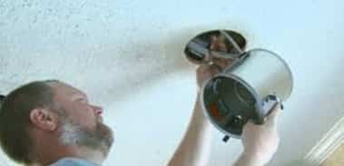 picture of an electrician installing a recessed lighting fixture into the ceiling of a residential home in Fort Lauderdale, Florida