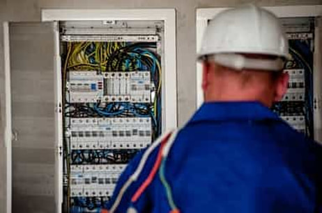 this is a picture of Fort Lauderdale Electricians working on a large circuit board at an industrial project in Broward County